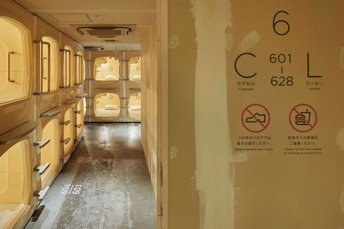 Corridor between rows of capsules with a bathing floor entrance at the far end