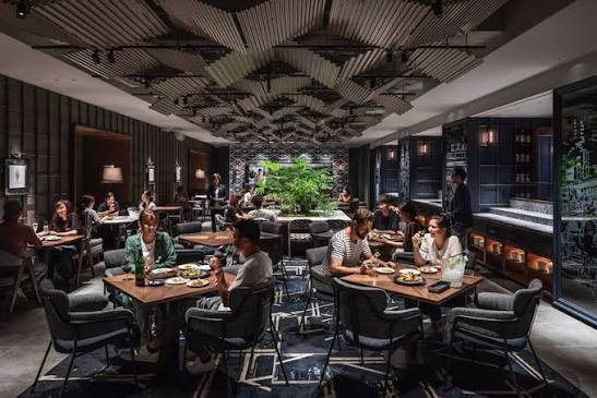 Tiered sleeping berths with pull-down screens beside a shared working table