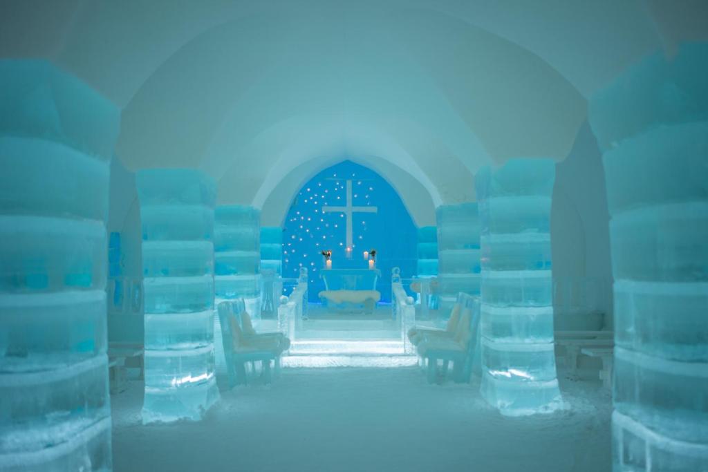 Carved snow wall beside a low doorway in a winter building