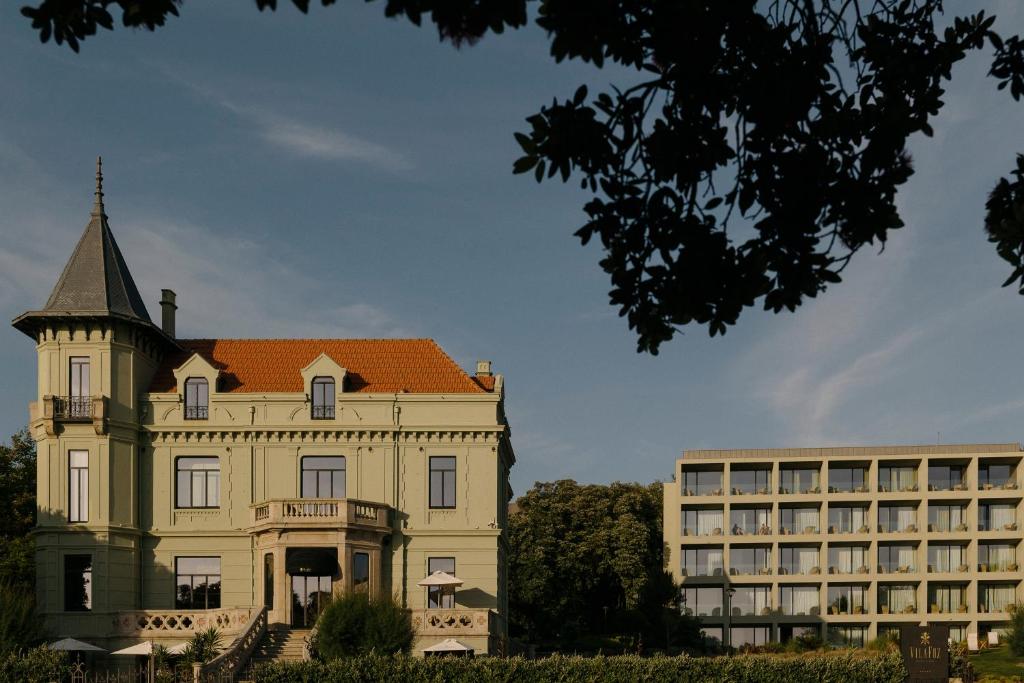 Stone mansion frontage facing a coastal avenue, with tall shuttered windows
